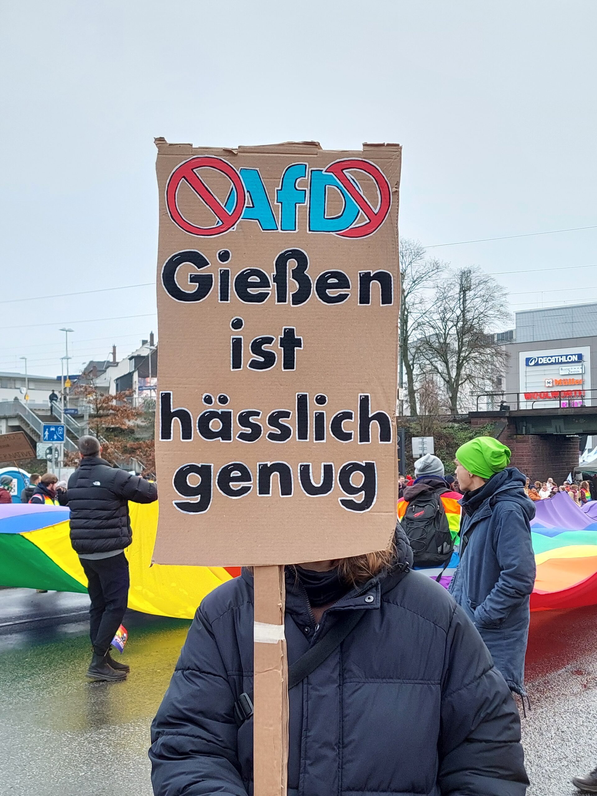 Eine Gießener Studentin hält ein Plakat hoch, auf dem steht: "AfD: Gießen ist hässlich genug".